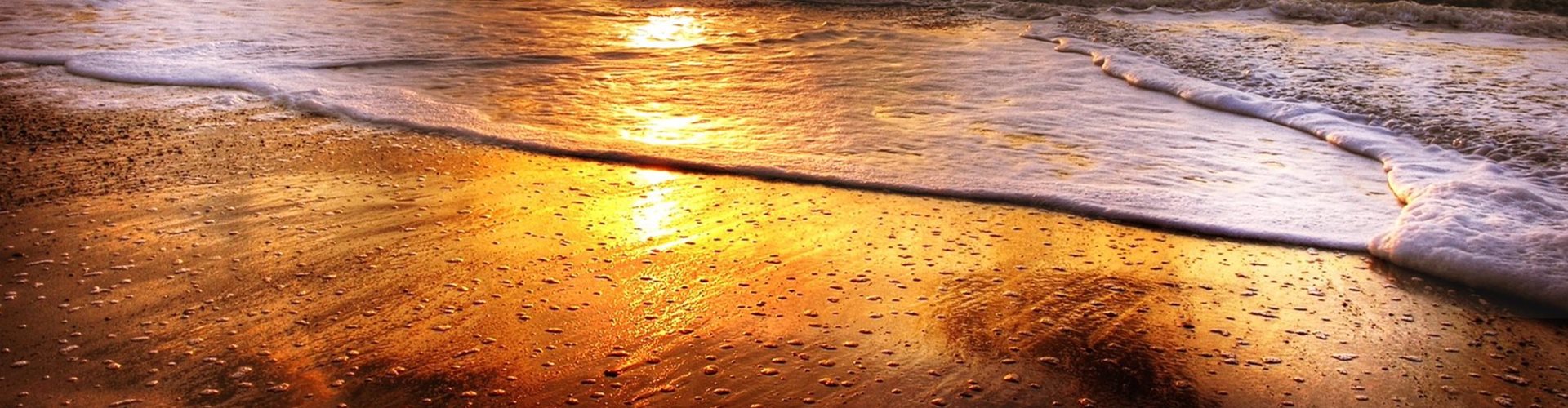 bølger på en strand i solnedgang