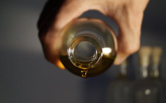 Olie hældes fra flaske. Ved behandling af ME - Myalgisk Encefalomyelities - med Perrin technique bruges olie ved lymfedrenage. 