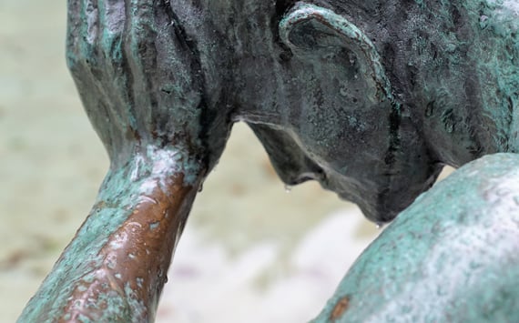 Statue der støtter sit hoved i hånden. Måske på grund af hovedpine? Hovedpine og migræne kan behandles med triggerpunktbehandling og med kranio sakral terapi