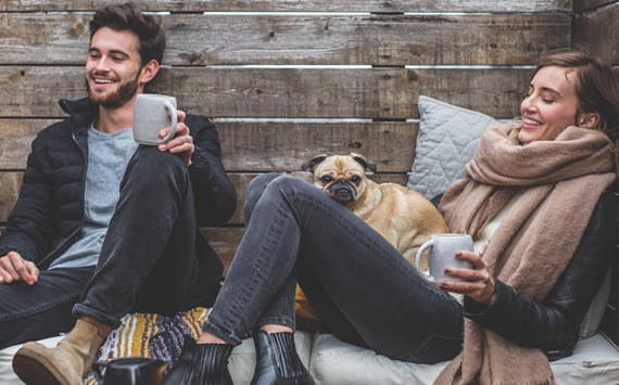 Ung mand og ung kvinde med mops der drikker kaffe, måske har de smerter