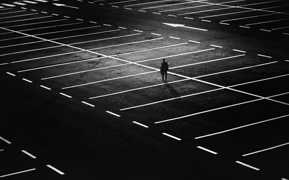 enlig mand på asfalt med rudemønster. Symbol på den ensomhed som langvarige smerter kan medføre. Smerter kan fjernes med triggerpunkter og kranio sakral terapi