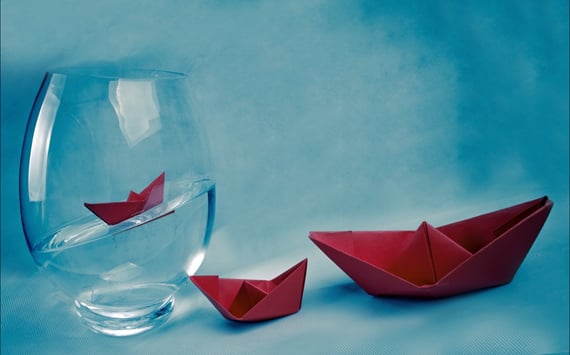 Vase med vand og rød papirbåd